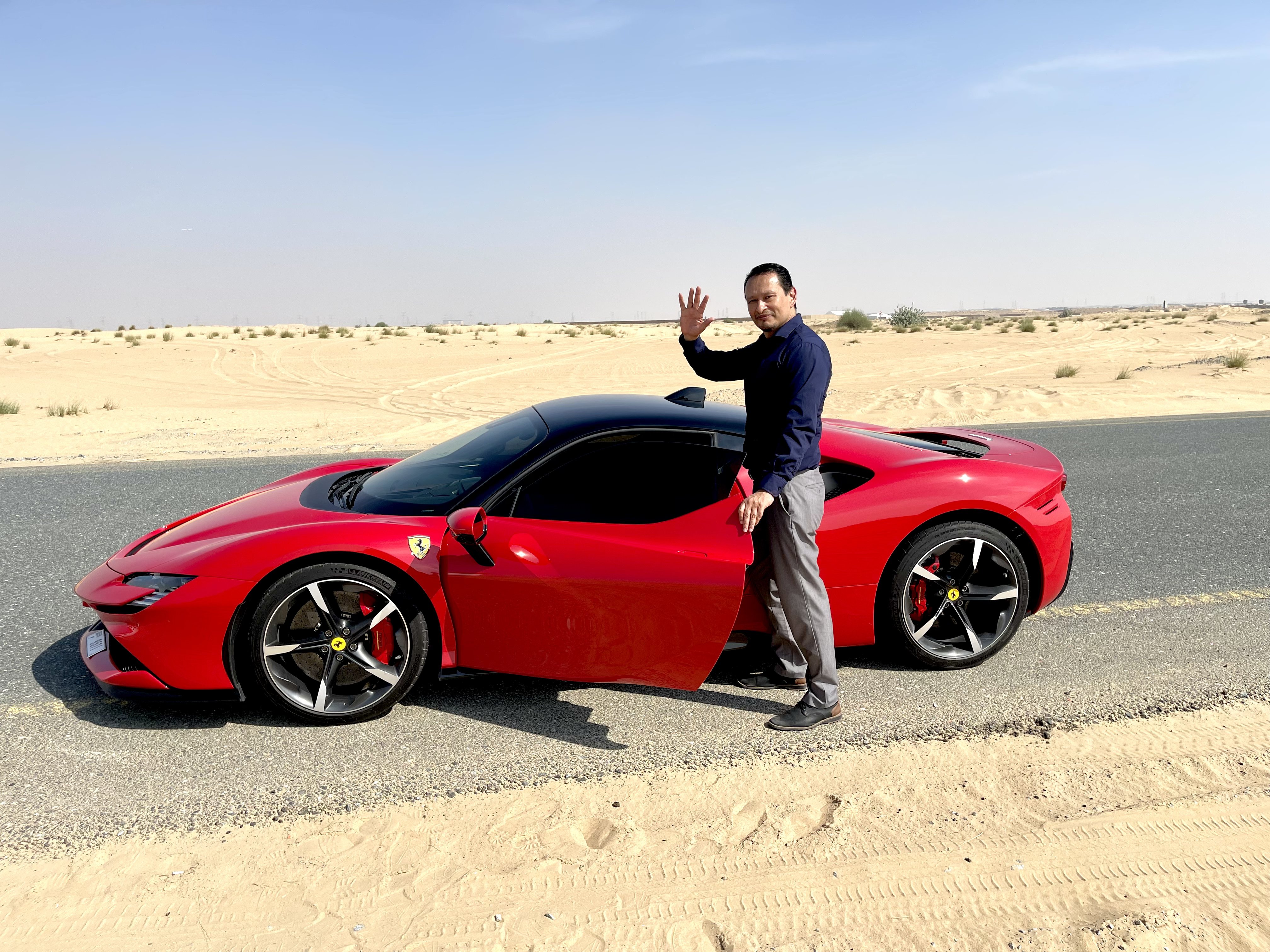 Gustavo junto a Ferrari rojo en desierto entre Dubái y Sharjah
