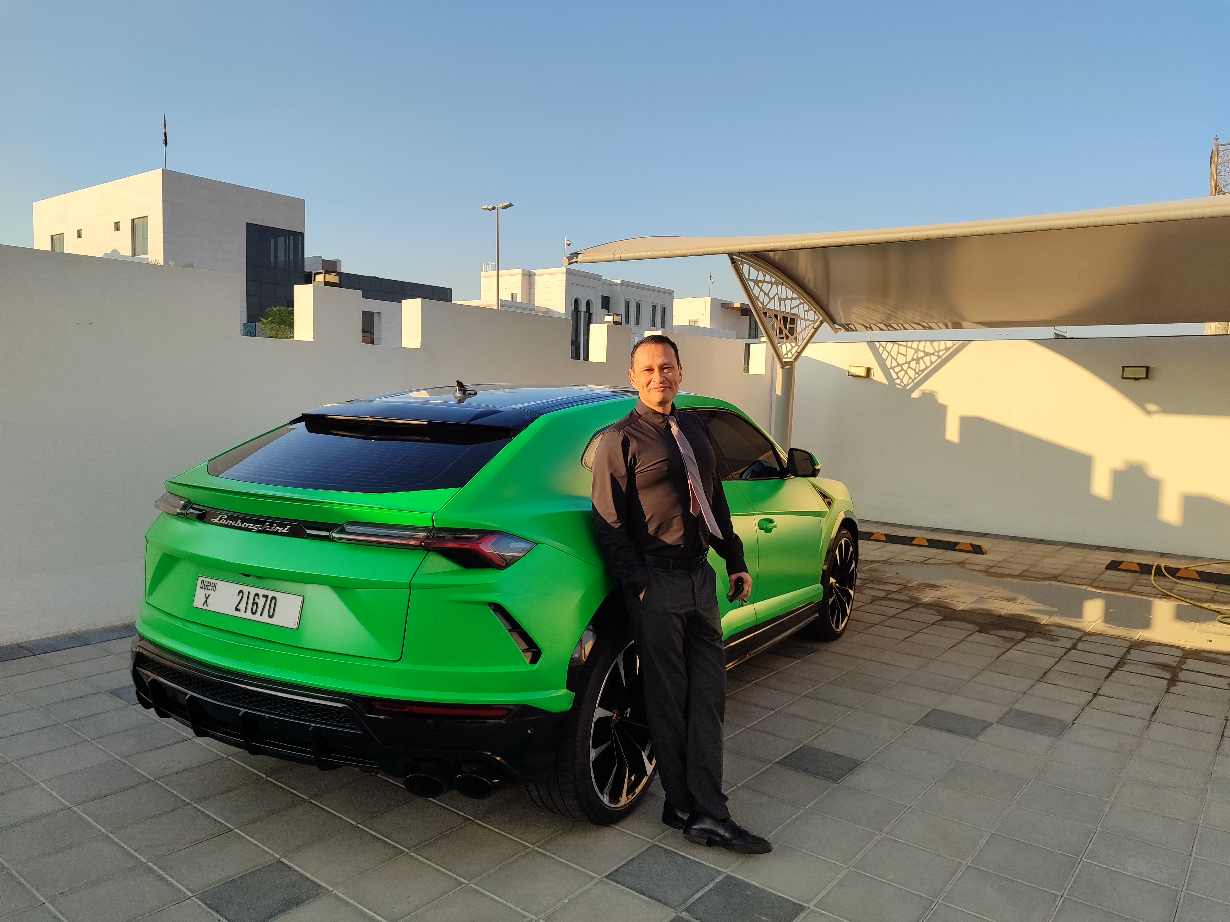 Gustavo junto al Lamborghini Urus verde brillante en Dubai