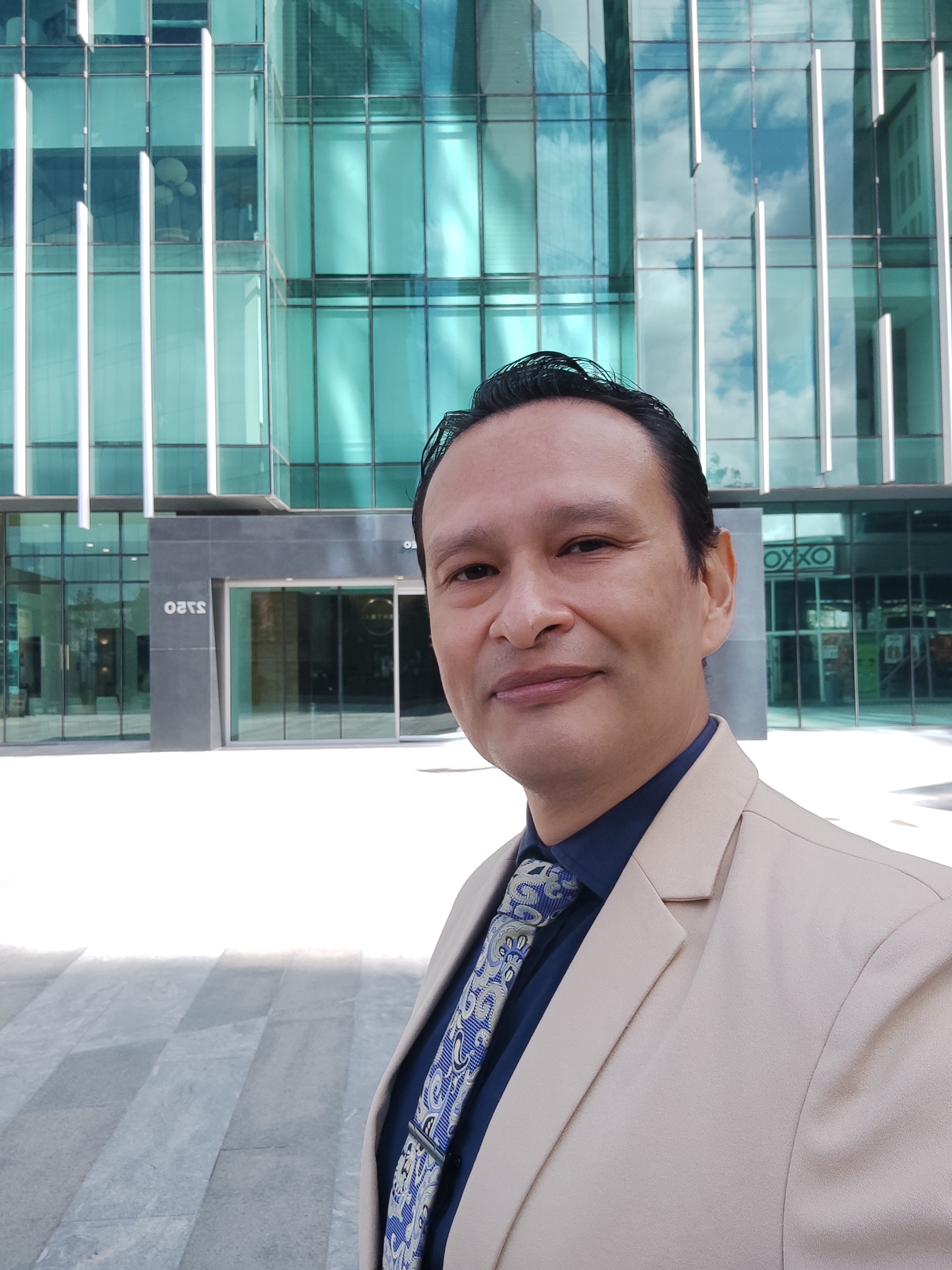 Hombre de negocios en Tijuana frente a edificio de vidrio